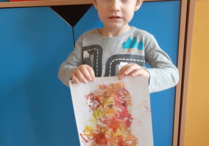 Adaś prezentuje wykonany przez siebie portret Pani Jesieni.